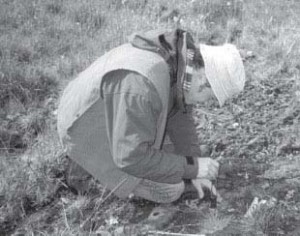 Scientist crouched down on ground making an observation